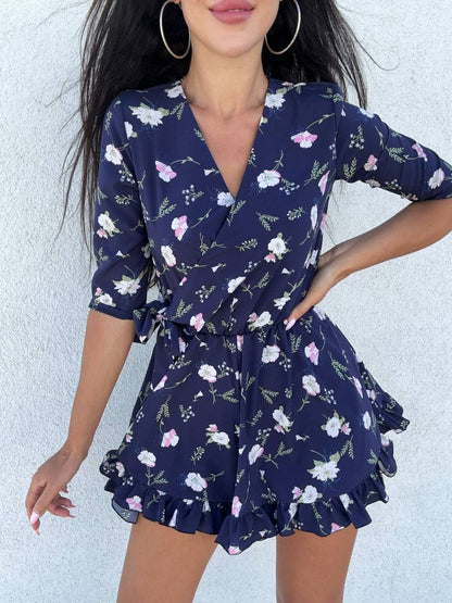 Woman wearing a navy floral dress against a light background