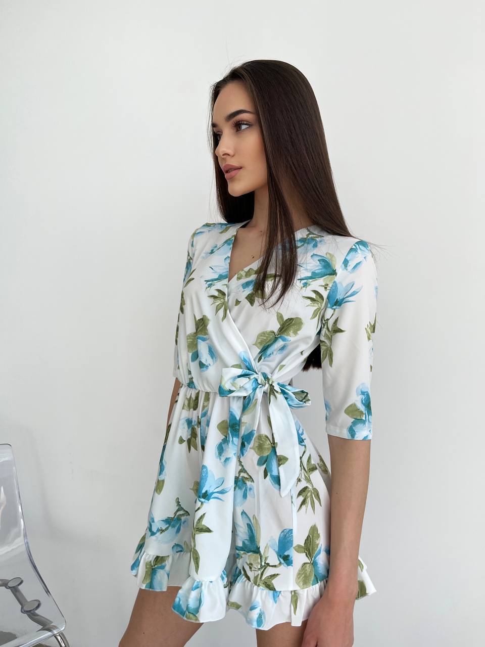 Woman wearing a floral dress against a white background