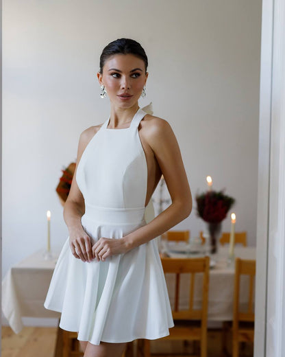 Woman in a white dress standing in a dining room setting