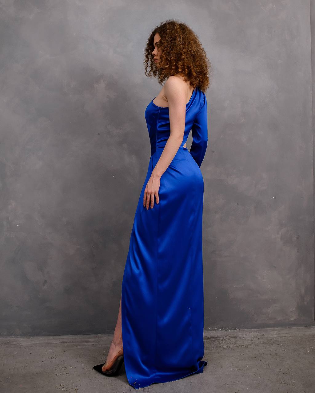 Woman wearing a blue evening gown against a gray background