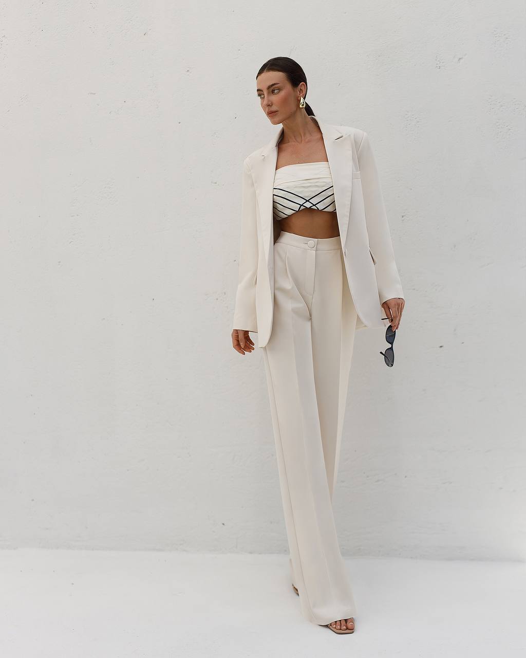 Woman wearing a white outfit with a black and white striped top against a white background