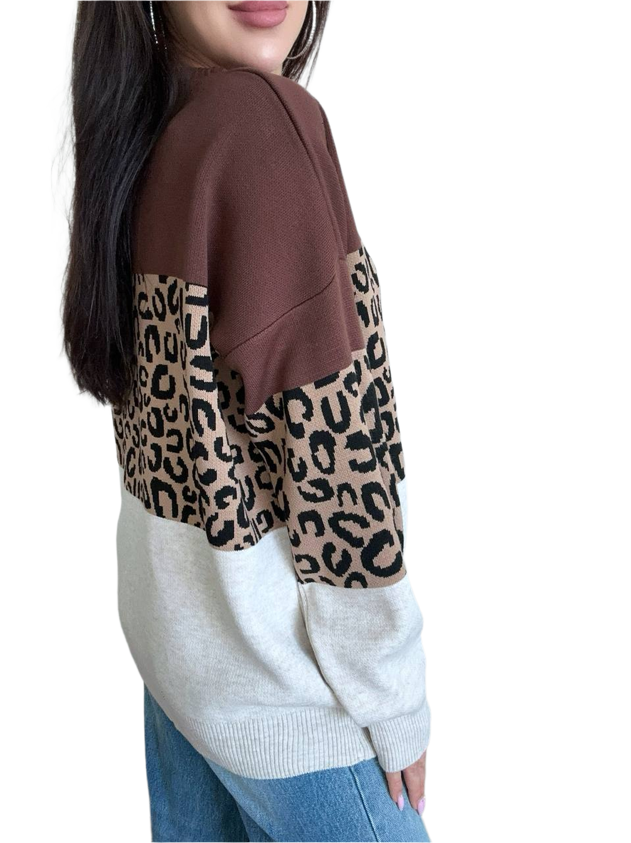 Person wearing a brown and beige sweater with leopard print pattern on a white background
