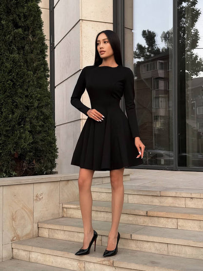 Woman in a black dress standing on steps outside a building