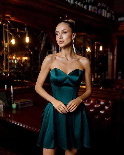 Woman in a strapless green dress standing in a bar setting