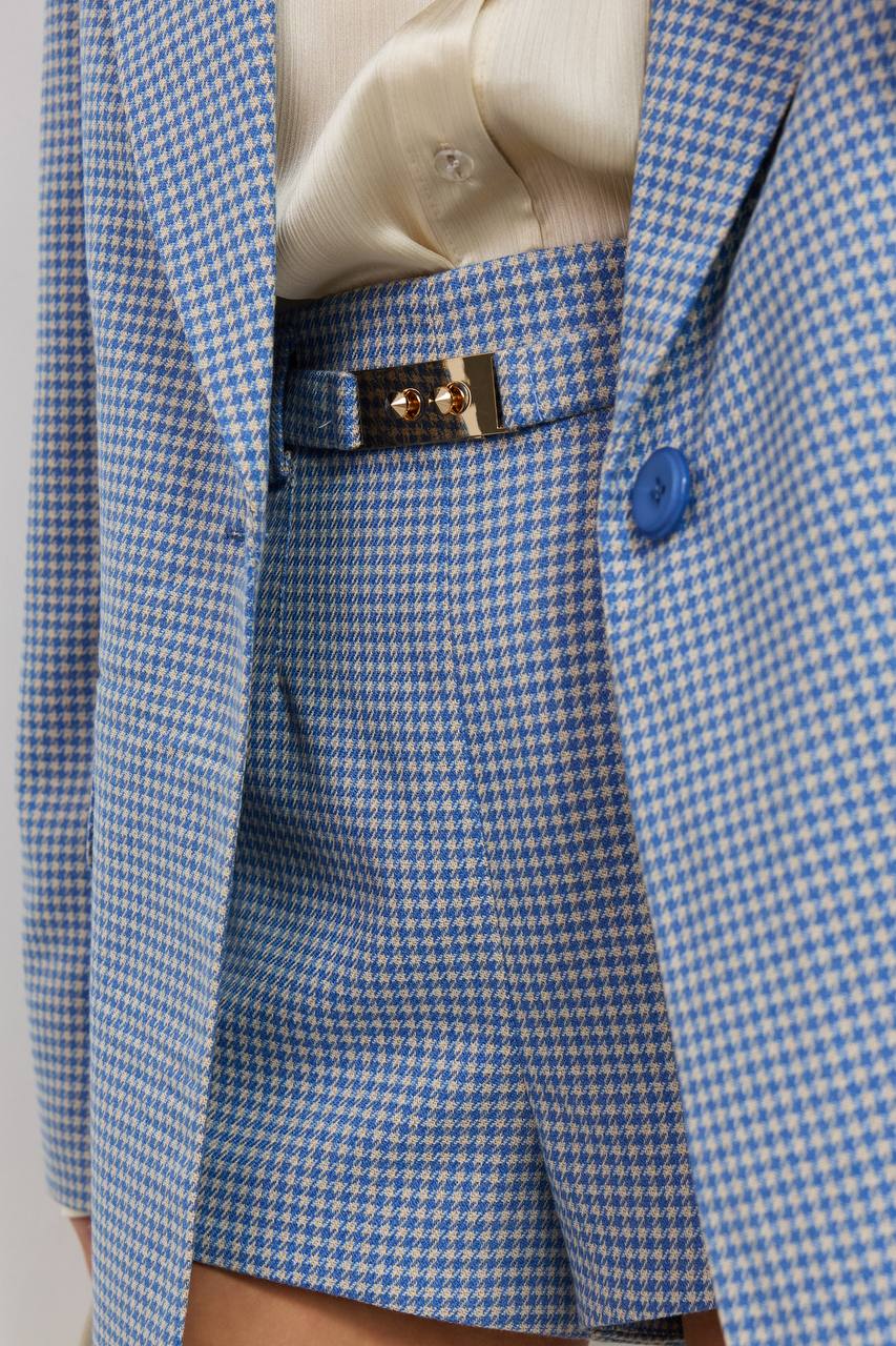 Blue and white checkered suit jacket with a close-up of a button on a plain background