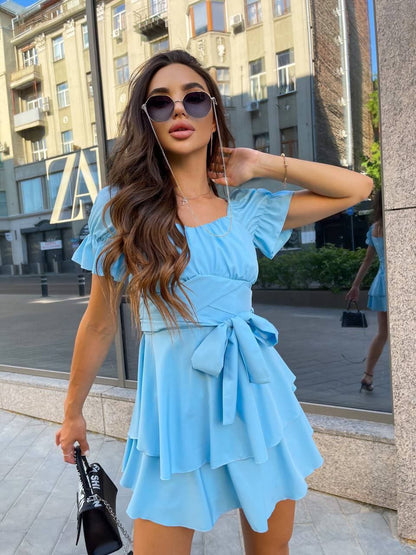 Woman in a light blue dress standing on a city street