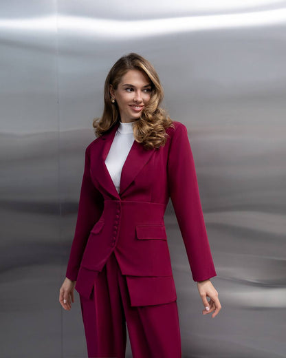 Woman wearing a magenta suit against a metallic background