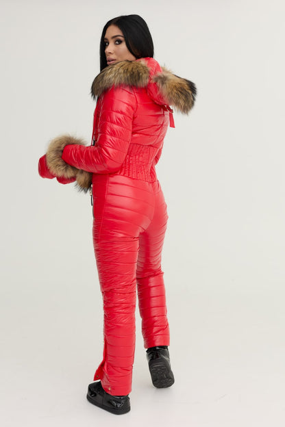 Person wearing a red puffer jumpsuit with fur trim on a white background