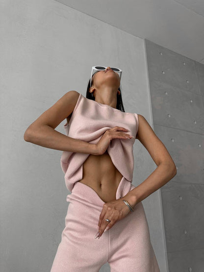 Person wearing a pink outfit against a gray wall
