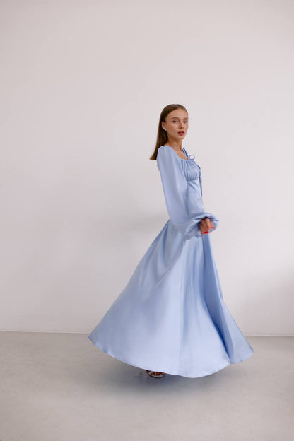 Woman wearing a light blue dress against a plain background