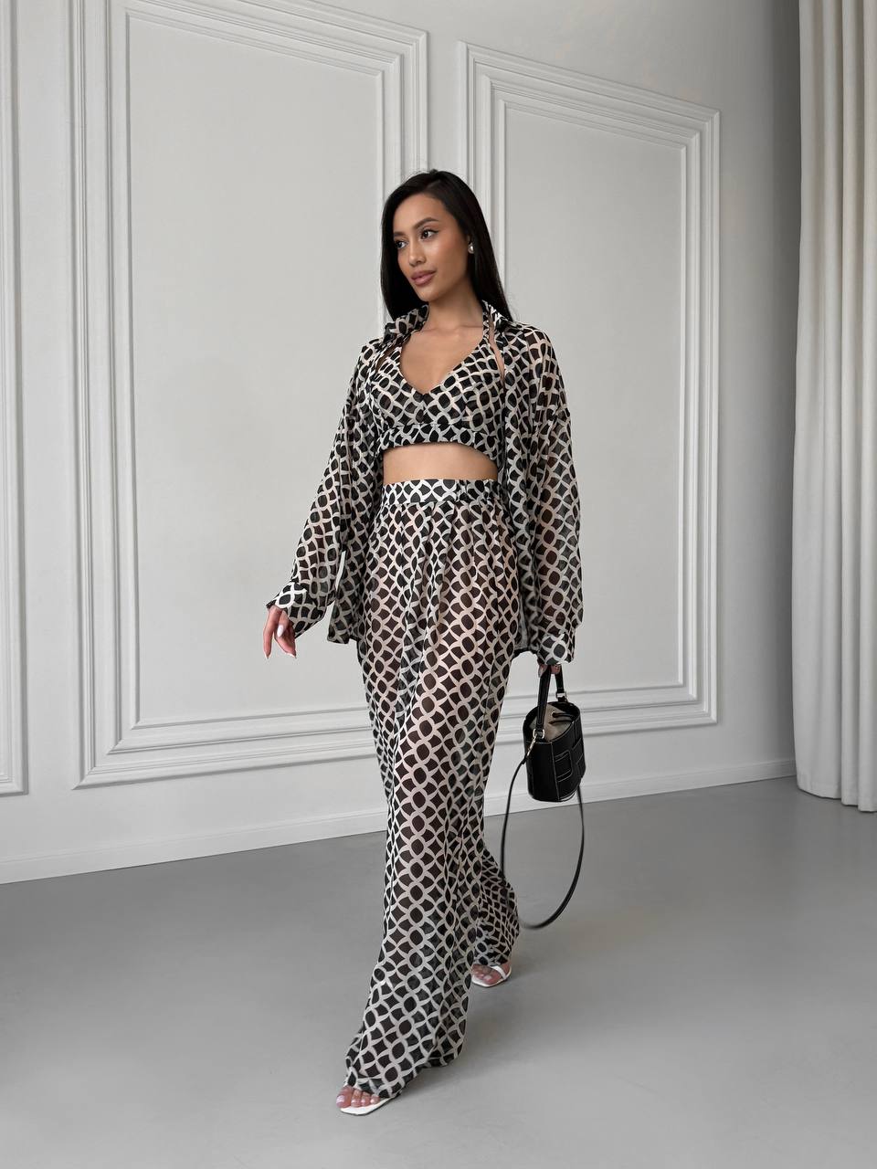 Woman wearing a patterned outfit in a minimalistic room