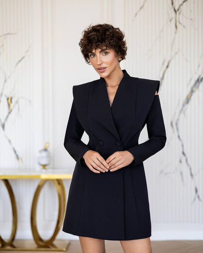 Woman wearing a black coat against a marble wall background