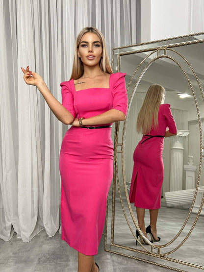 Woman in a bright pink dress standing in front of a mirror.