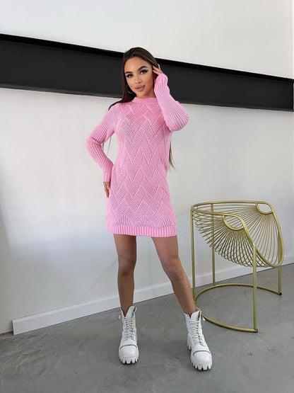 Woman wearing a pink knitted dress with white sneakers in a minimalistic setting
