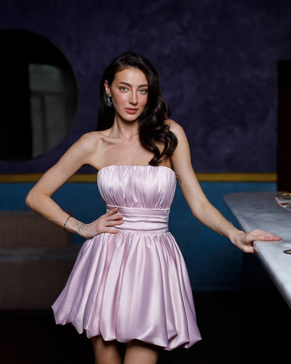 Woman wearing a pink strapless dress in an indoor setting