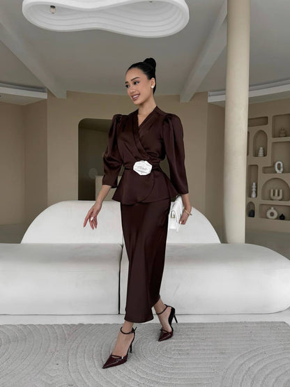 Woman in a brown outfit standing in a modern interior setting