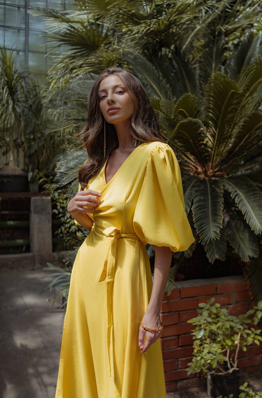 Woman in a yellow dress standing among plants