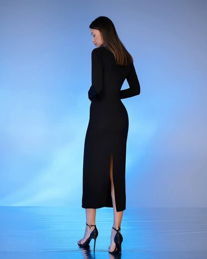 Woman wearing a black dress with a slit on a blue gradient background