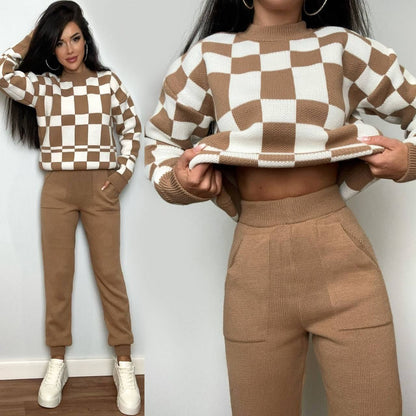 Two people wearing a brown and white checkered sweater and matching pants against a plain background.