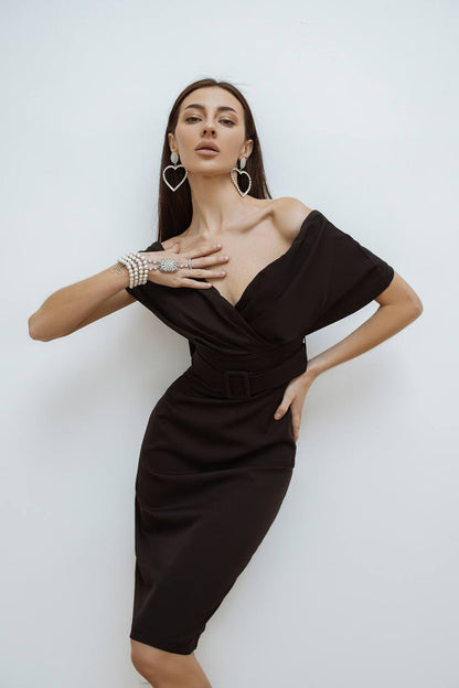 Woman wearing a black off-shoulder dress against a white background