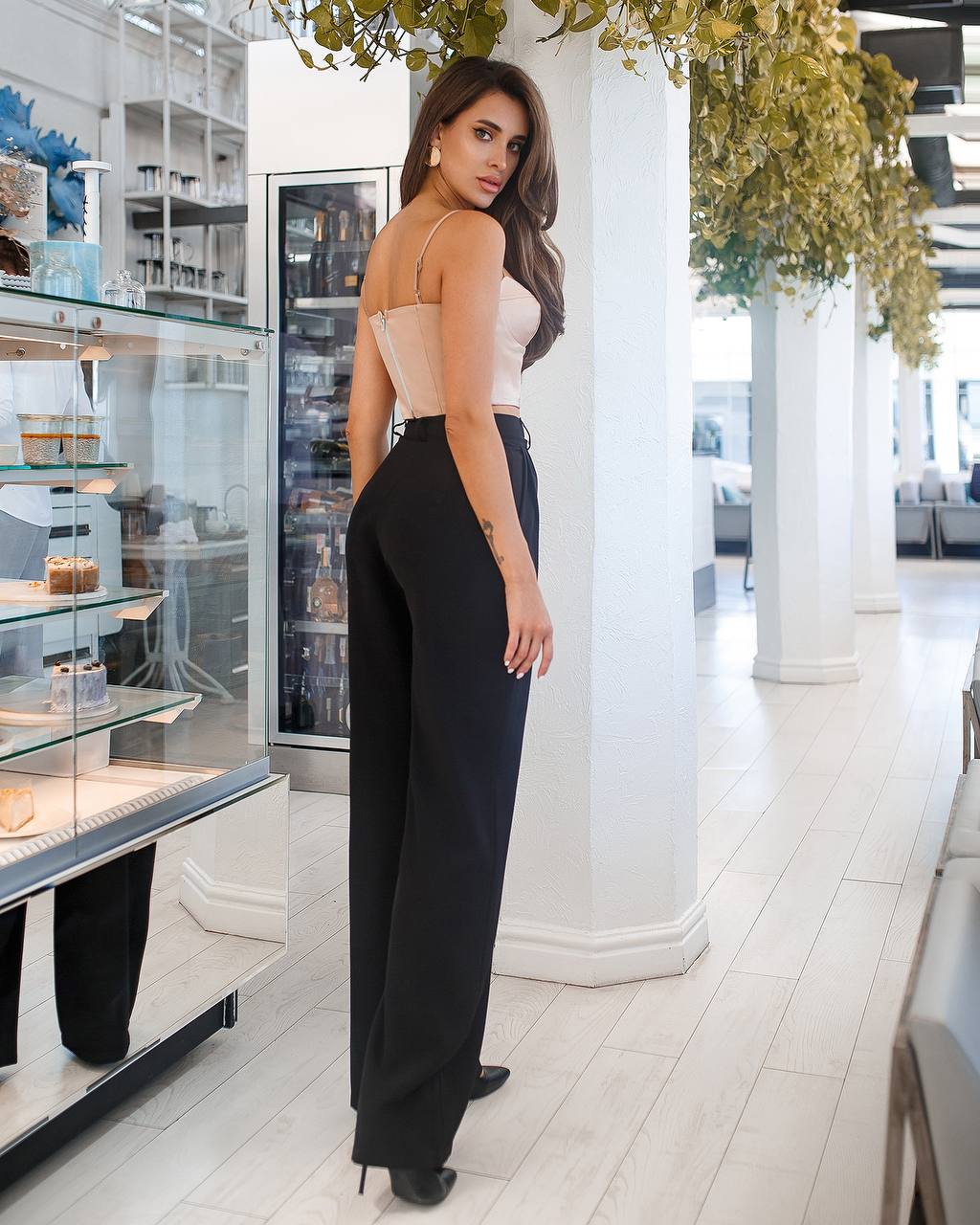 Woman in a stylish outfit standing in a modern interior setting