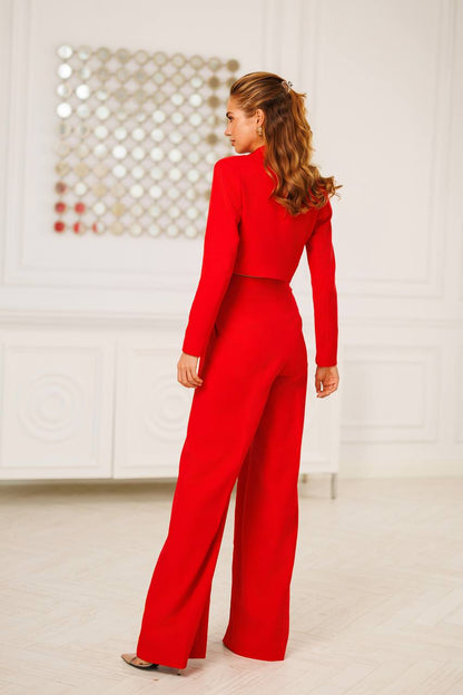 Person wearing a red jumpsuit in a minimalistic room.
