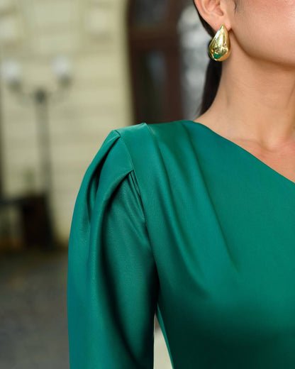 Green dress with puffed sleeves worn by a person, with a blurred background