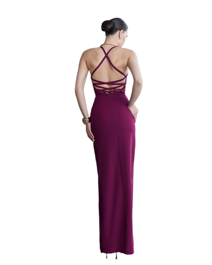 Woman wearing a burgundy evening gown with a backless design on a white background