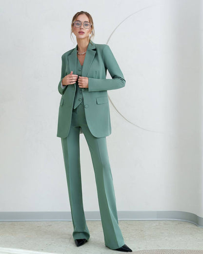 Woman wearing a green suit against a plain background