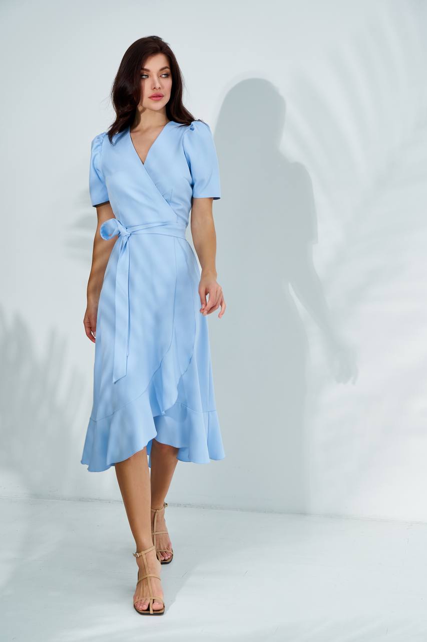 Woman wearing a light blue dress against a white background