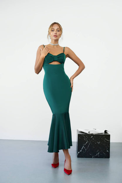 Woman wearing a green dress with cut-out design on a white background