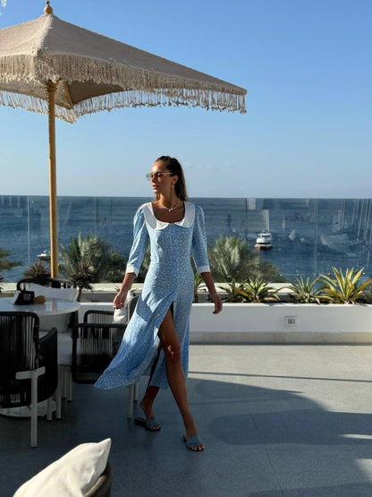 Woman in a blue dress walking on a rooftop with ocean view