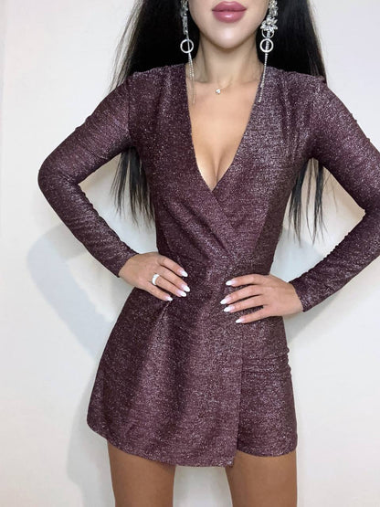 Woman wearing a sparkly purple dress with long sleeves on a white background