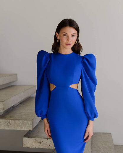 Woman wearing a blue dress with puffed sleeves standing on a staircase.