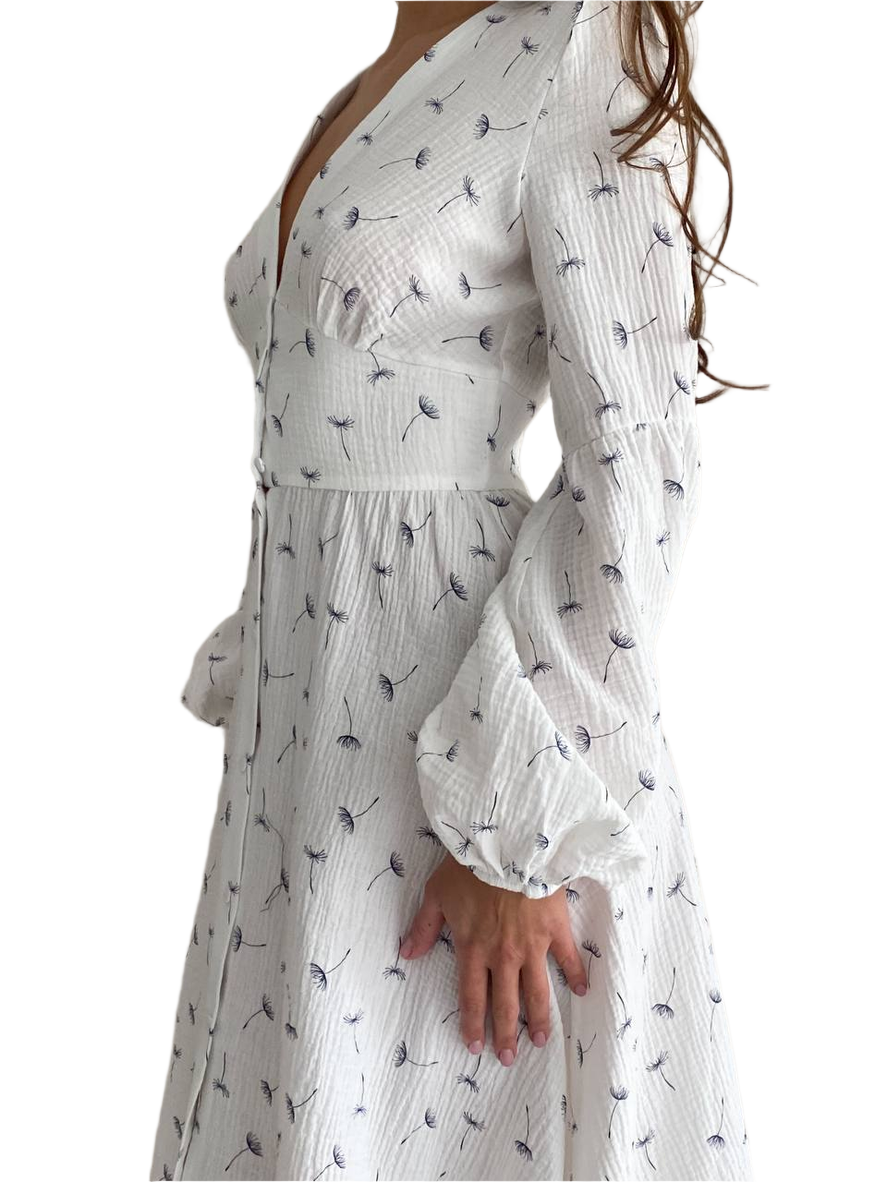 White dress with black floral pattern worn by a person on a white background