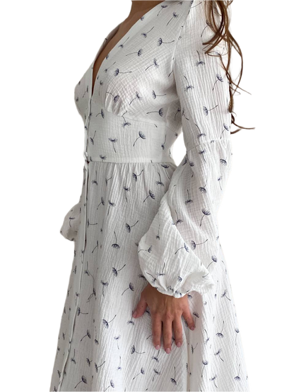 White dress with black floral pattern worn by a person on a white background