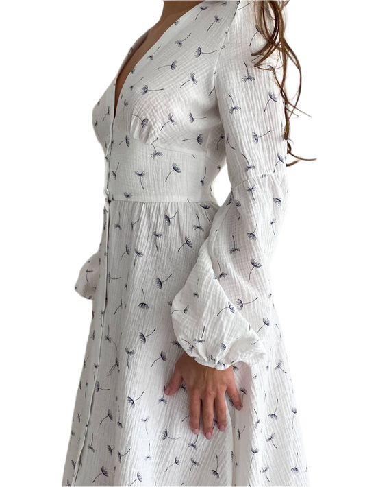 White dress with black floral pattern worn by a person on a white background