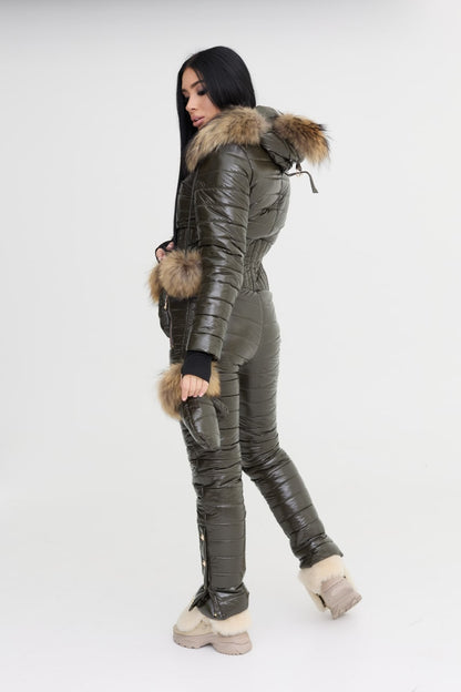 Person wearing a gray quilted jumpsuit with fur trim on a white background