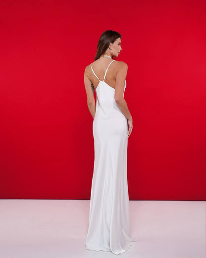 Woman wearing a white dress against a red background