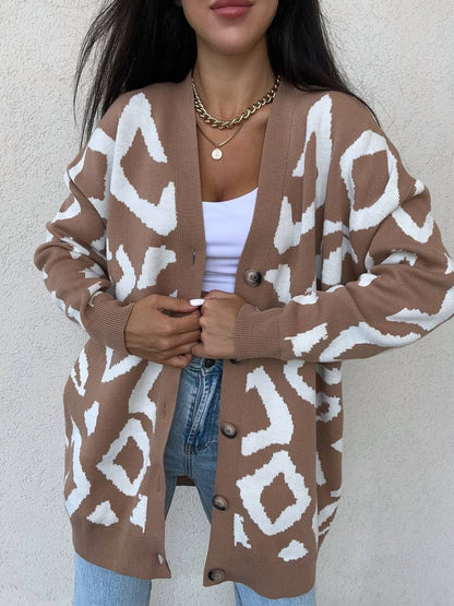 Person wearing a brown cardigan with white pattern against a plain background