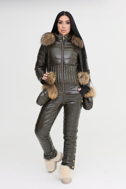 Woman wearing a dark green puffer jumpsuit with fur trim on a white background