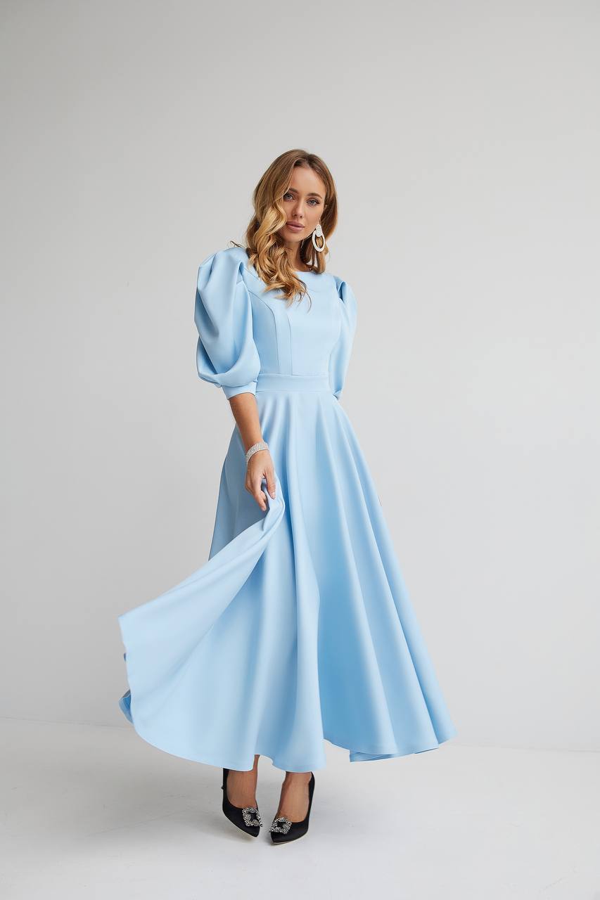 Woman wearing a light blue dress with puffed sleeves on a white background