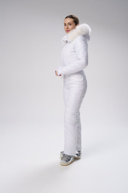 Person wearing a white puffer suit with fur trim on a gray background
