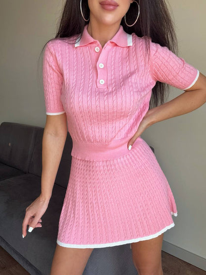 Person wearing a pink textured dress with white trim indoors.