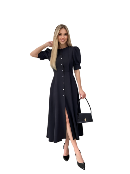 Woman wearing a black dress with puff sleeves and a high slit, holding a matching handbag on a white background.