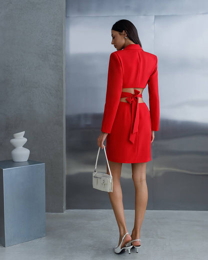 Woman in a red outfit holding a white handbag against a gray background