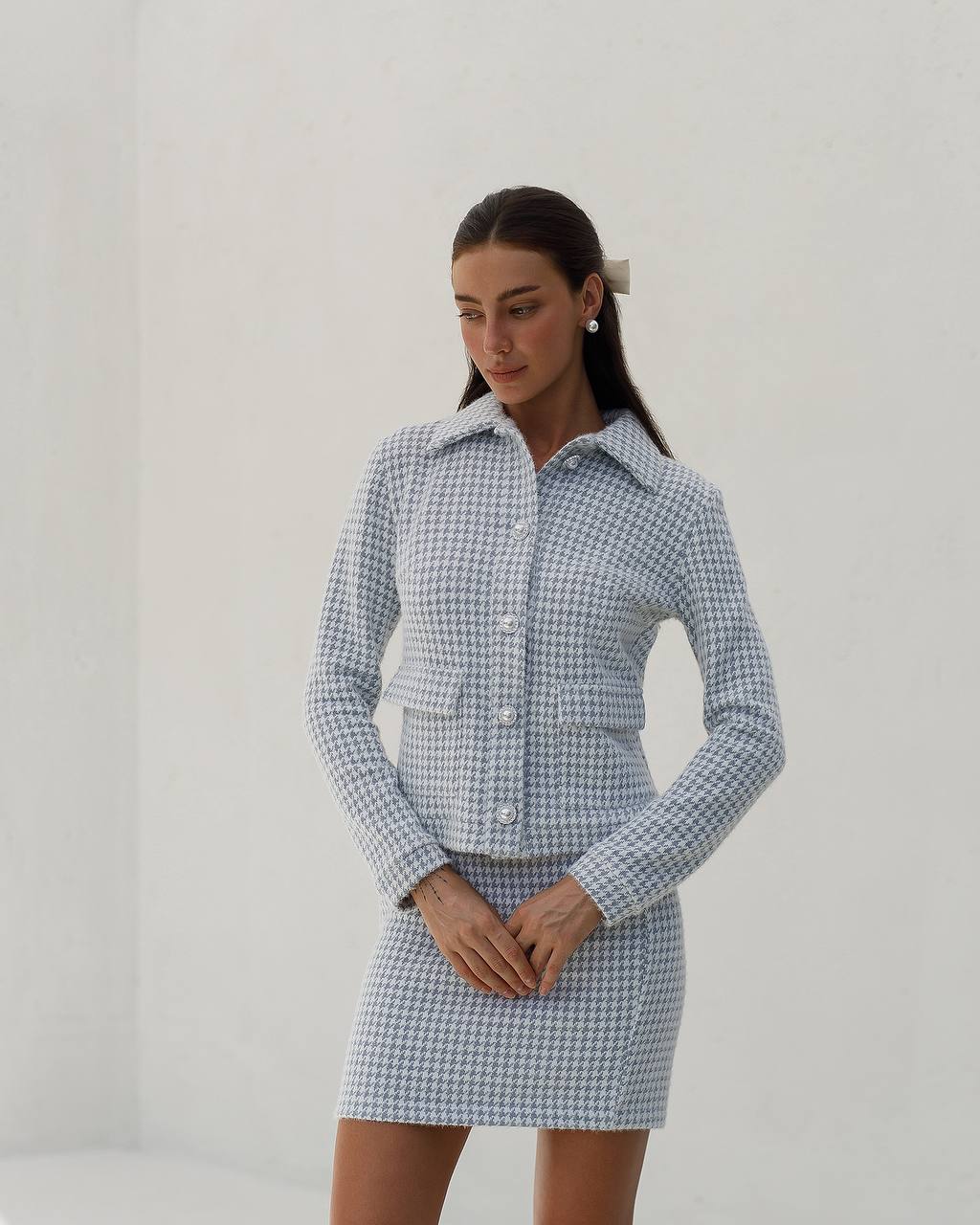 Woman wearing a blue and white checkered dress against a plain background