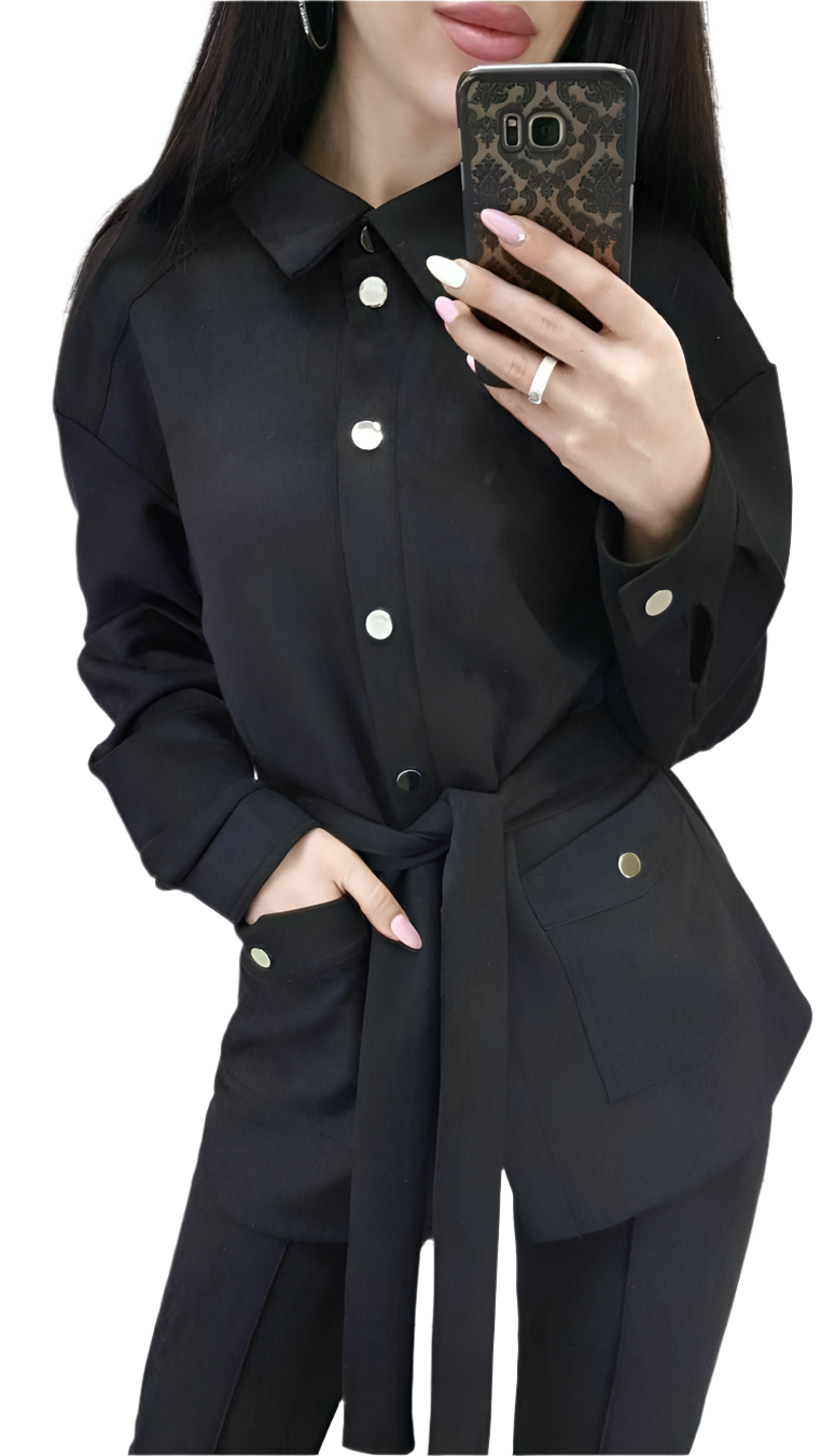Person wearing a black outfit with white buttons, holding a phone.