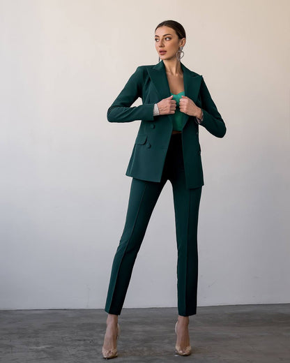 Woman wearing a green suit against a plain background