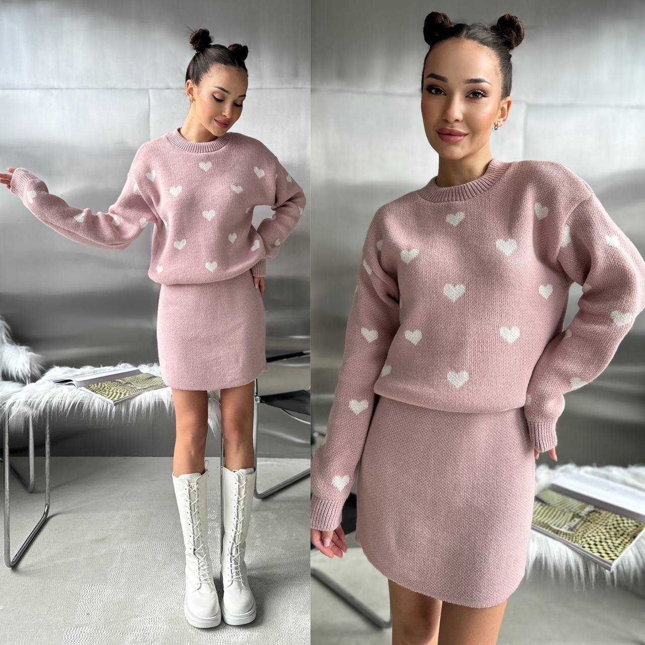 Woman wearing a pink sweater and skirt set with heart patterns in a room.